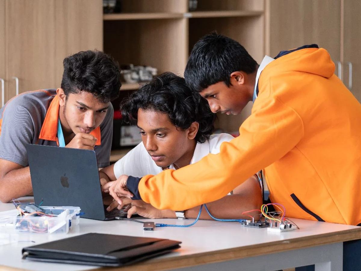 students troubleshooting a code in a laptop
